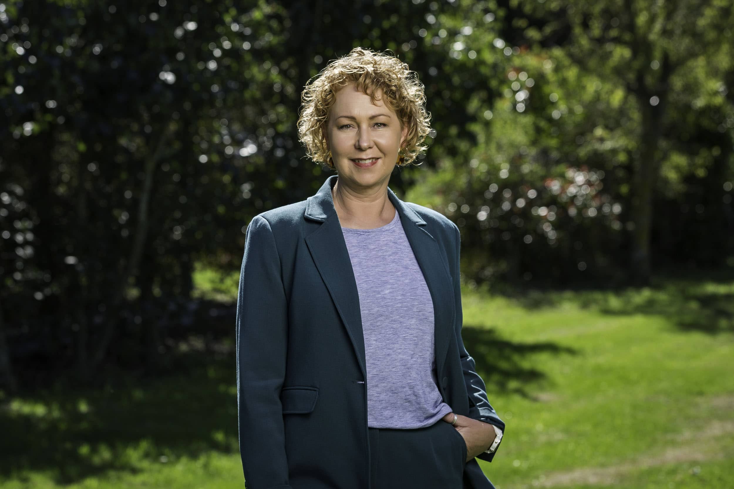 Natural garden portrait showing a relaxed business woman, photographed using flash and natural backlight.