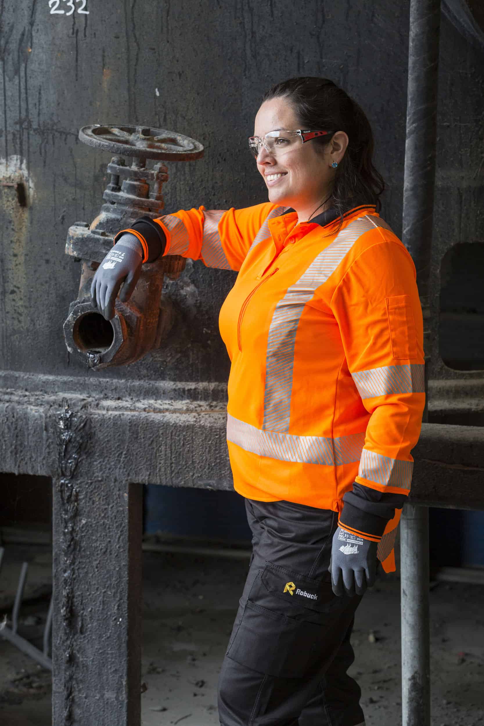 Model with full personal protective gear posing by oil tank.