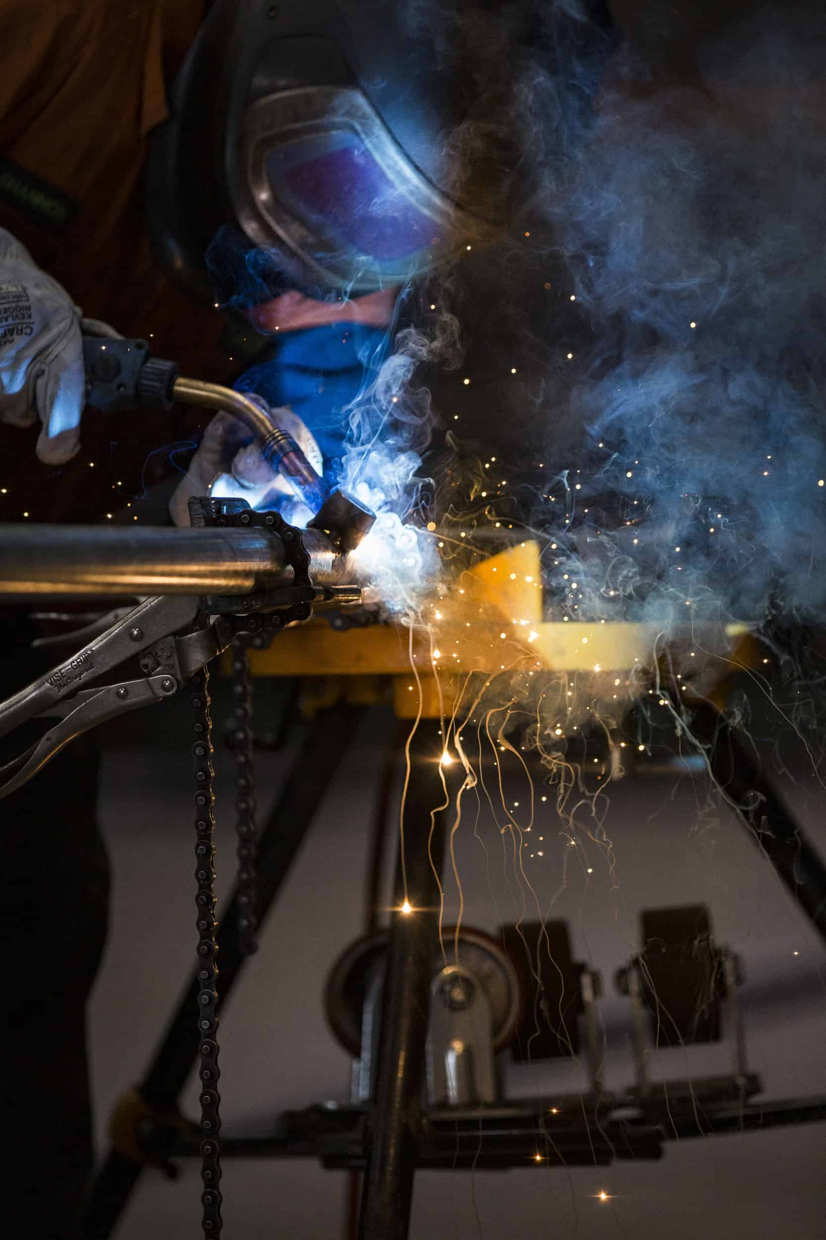 Welding pipe with sparks and smoke.