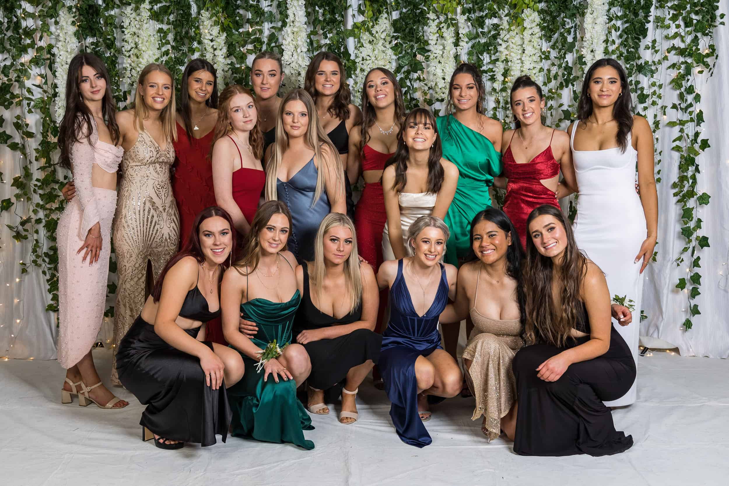 Girls pose as a large group at their school formal.