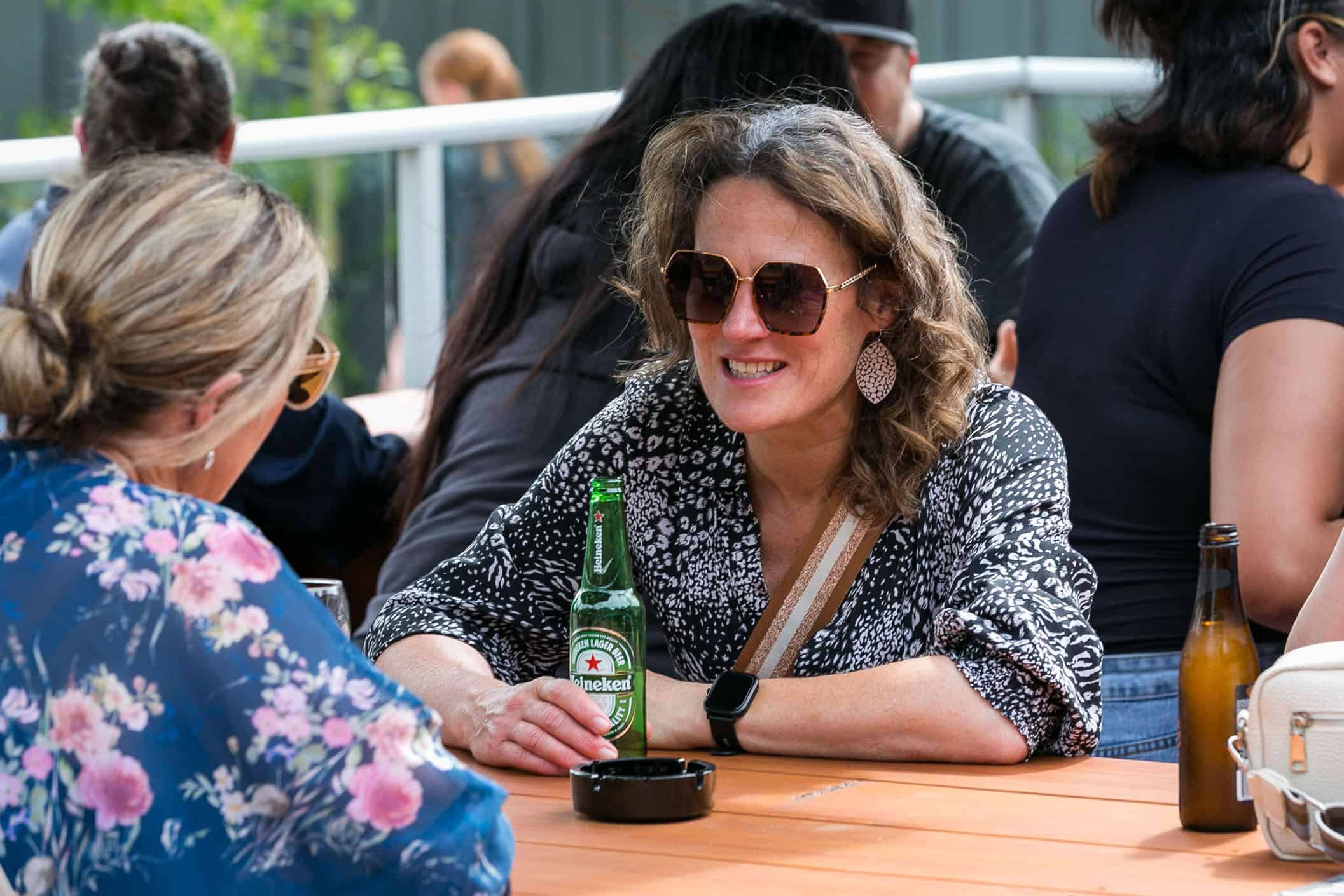 Casual photo of people talking over a table smiling at a work Christmas function.