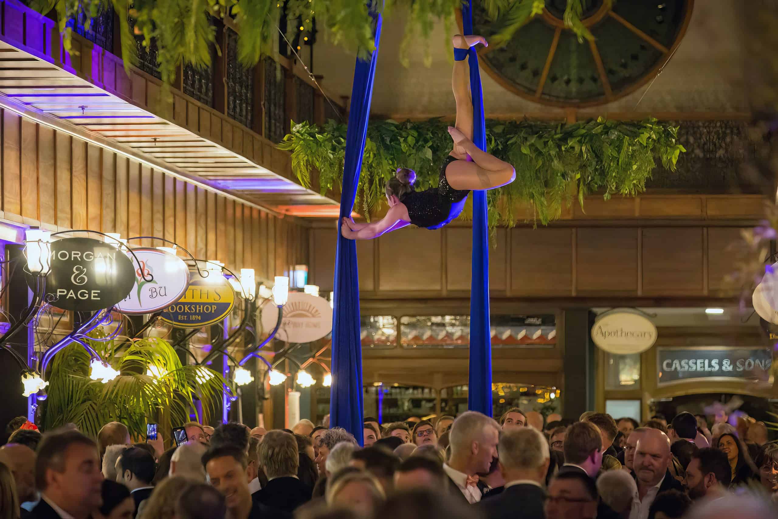 Aerial performer on ribbons performs above a large crowd enjoying an event hospitality event at The Tannery, Christchurch.