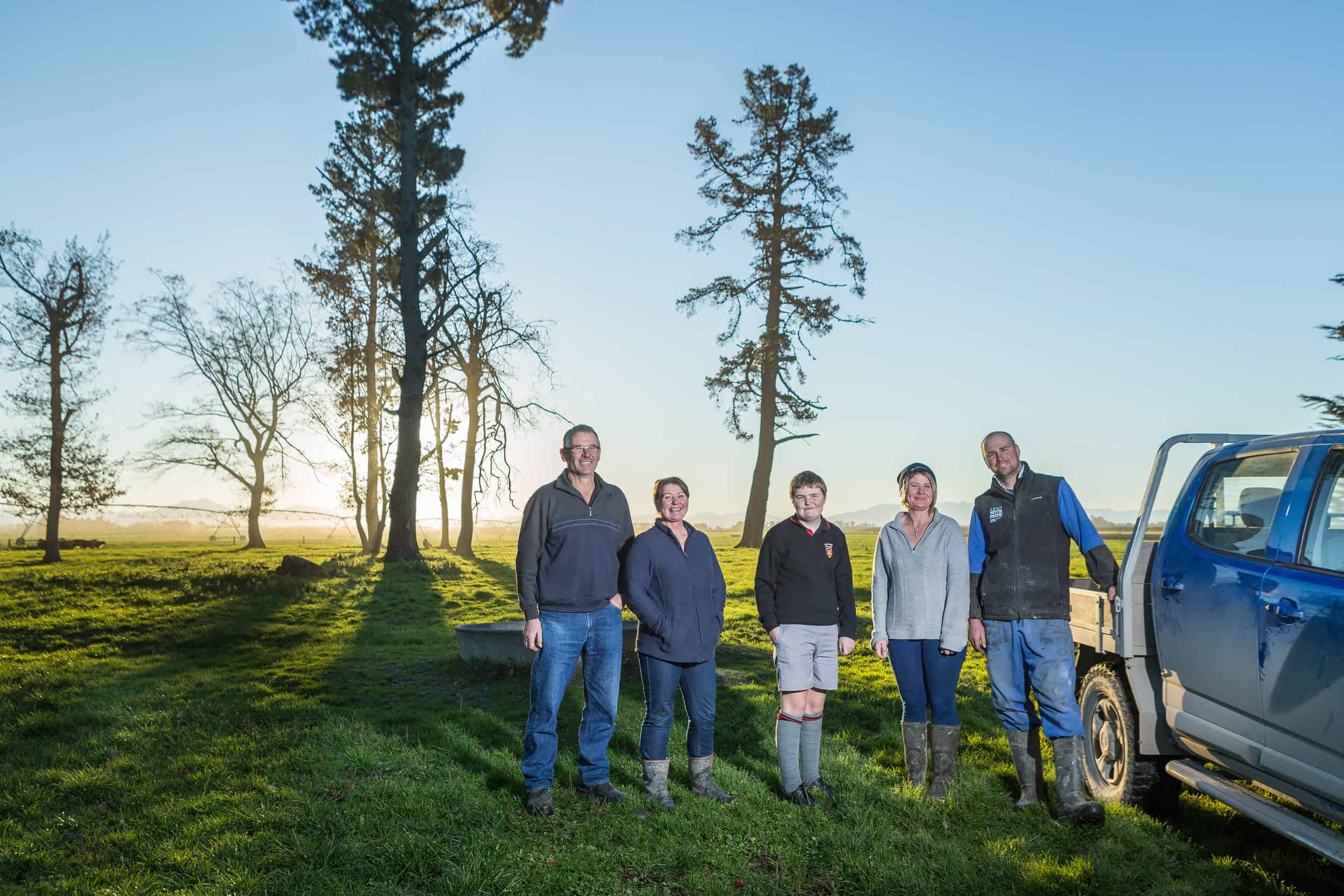 Rural family with ute pose in paddock.