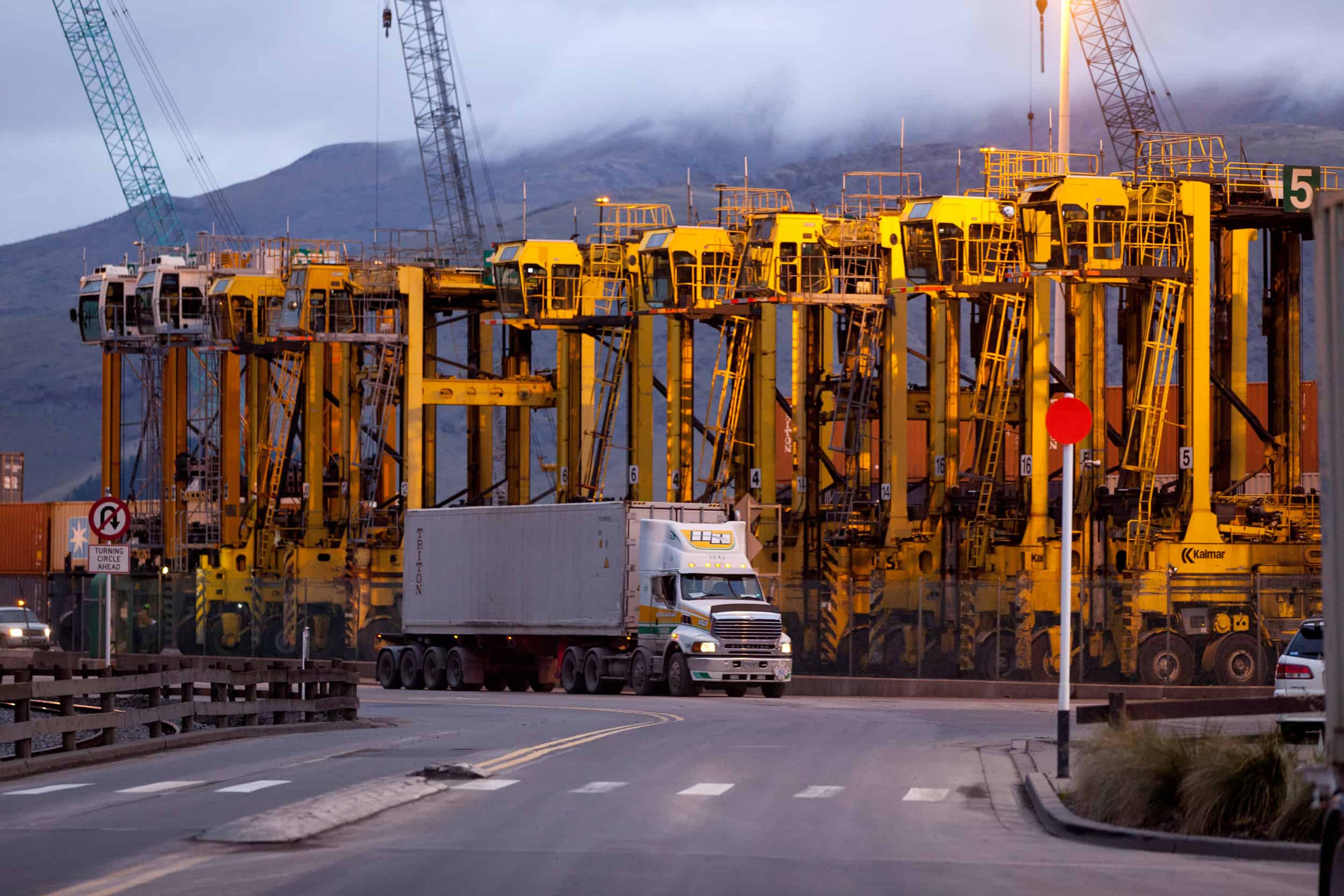 Hilton Haulage truck with container passes straddles at Port of Lyttelton.