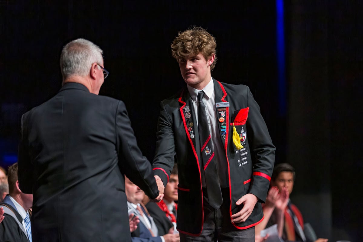 Scholarship prize winner receives award on stage at school graduation.