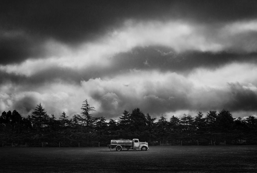 Moody black and white fine art photo of an abandoned truck in paddock.